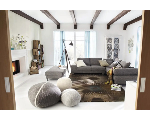 Světlý obývací pokoj s šedou rohovou sedačkou, otomany, dekorativními polštáři, knihovnou, krbem a dekorací