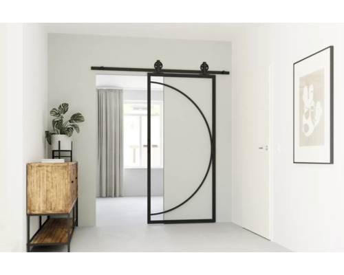 Interiér chodby s posuvnými skleněnými a kovovými dveřmi s kruhovým designem, dřevěnou skříní s rostlinou a zarámovaným obrazem na stěně