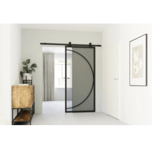 Pohled na pokoj se skleněnými posuvnými dveřmi s půlkruhovým designem, komodou, rostlinou a zarámovaným obrazem