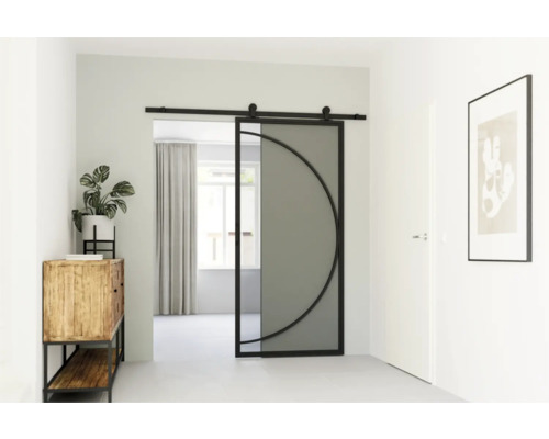 Pohled na pokoj se skleněnými posuvnými dveřmi s půlkruhovým designem, komodou, rostlinou a zarámovaným obrazem