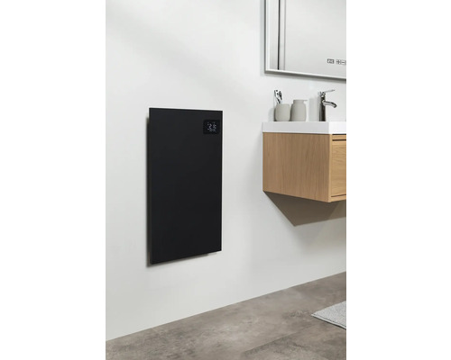 Koupelna s černým topným panelem na stěně vedle umyvadla