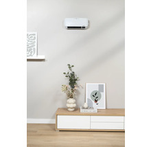 Obývací pokoj s nástěnným topným ventilátorem nad komodou zdobenou vázou