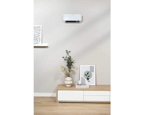 Obývací pokoj s nástěnným topným ventilátorem nad komodou zdobenou vázou