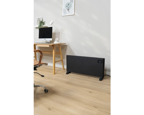 Kancelář se stolem, počítačem, kancelářskou židlí a černým radiátorem