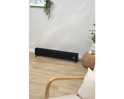 Elektrický radiátor v obývacím pokoji se světlou dřevěnou podlahou.