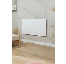 Obývací pokoj s topným panelem na stěně a křeslem