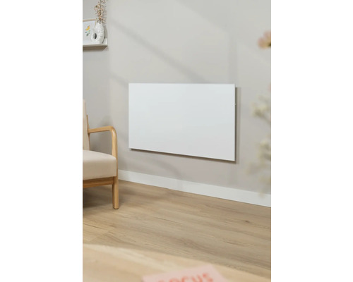 Obývací pokoj s topným panelem na stěně a křeslem