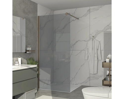 Moderní koupelna se skleněnou sprchovou zástěnou, umyvadlem a toaletou