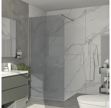 Moderní koupelna s rovnou sprchou, umyvadlem a mramorovými obklady.