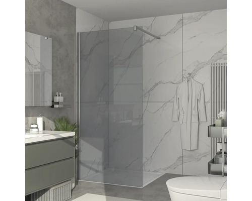 Moderní koupelna s rovnou sprchou, umyvadlem a mramorovými obklady.