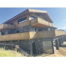 Vícepodlažní dům s dřevěným obkladem, kamenným zdivem a balkony