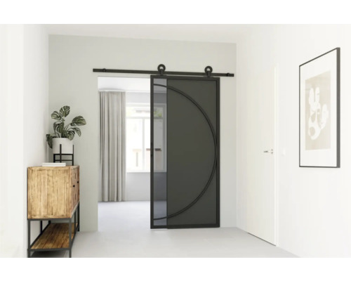 Interiér chodby se skleněnými kovovými posuvnými dveřmi, dřevěnou skříňkou a pokojovou rostlinou.