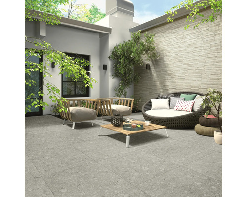 Venkovní prostor s terasovými dlaždicemi, sedacím nábytkem a dekoracemi pro stylovou zahradu