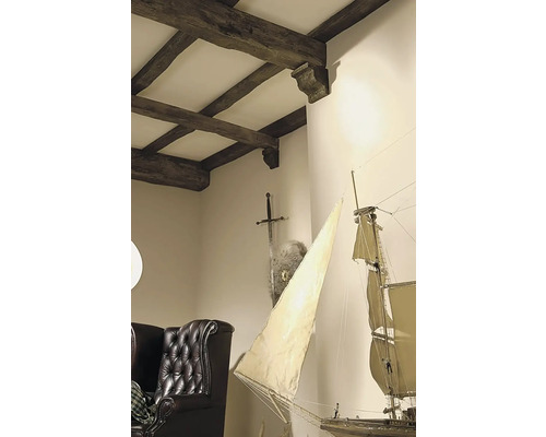 Interiérová fotografie obývacího pokoje s dřevěným trámovým stropem, mečem, štítem, modelem plachetnice a koženým křeslem