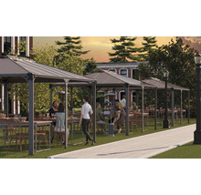 Několik altánů se stoly a židlemi na trávníku pro venkovní použití.