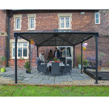 Zahradní pavilon s rodinou a jídelním stolem venku před cihlovou budovou