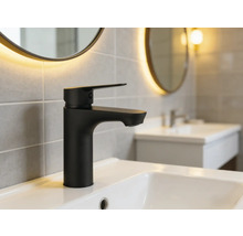 Černá umyvadlová baterie na umyvadle v koupelně.