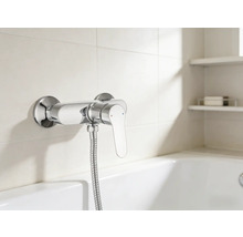 Nástěnná sprchová baterie se sprchovou hadicí v koupelně