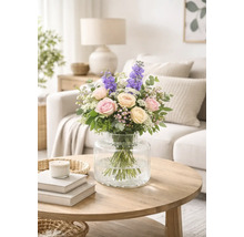 Kytice růží a ostrožky v skleněné váze na stole