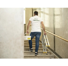 Muž nese kbelík s barvou a žebřík po schodech