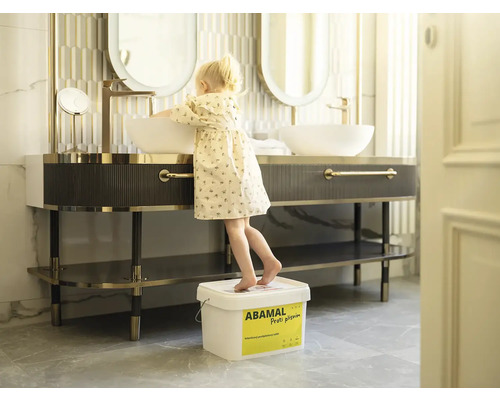 Moderní koupelna s umyvadlem, zrcadlem, baterií a dítětem na kbelíku