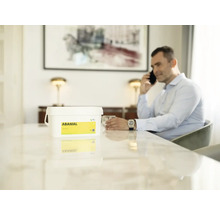 Kbelík přípravku na ochranu rostlin Abamal na stole, muž telefonuje v pozadí