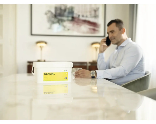 Kbelík přípravku na ochranu rostlin Abamal na stole, muž telefonuje v pozadí