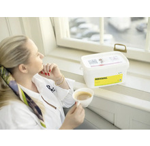 Žena s šálkem kávy vedle nádoby s hydroizolací do vlhkých místností