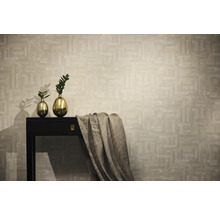 Pohled do místnosti s tapetou se vzorem, stolem, zlatými vázami a látkou