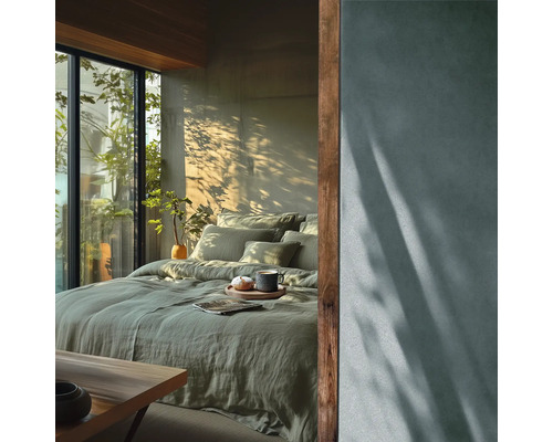 Ložnice s postelí, polštáři, přikrývkou a rostlinami vedle okna