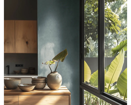 Světlá kuchyně s dřevěnými prvky, nádobí a rostlina ve váze na komodě