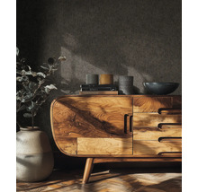 Obývací pokoj s dřevěnou komodou, knihami, dekorací a rostlinou v květináči