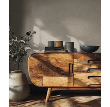 Dřevěná komoda se zásuvkami, na níž jsou knihy, mísy a rostlina ve váze