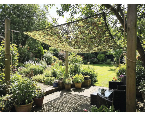 Zahrada s maskovací sítí jako ochrana proti slunci nad posezením