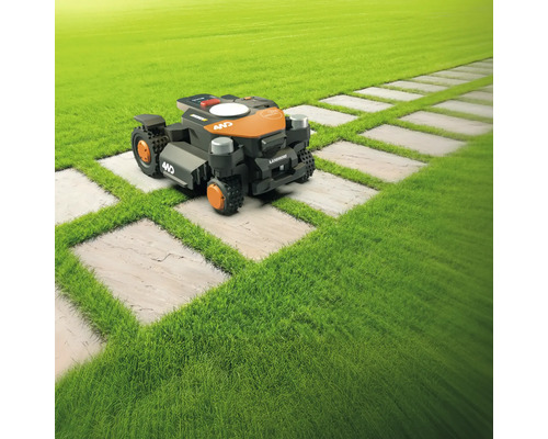 Robotická sekačka na trávníku s cestou z kamenných desek