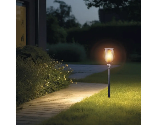 Zahrada se svítící solární pochodní podél cesty