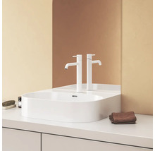 Moderní koupelna s bílým umyvadlem na desku a bateriemi