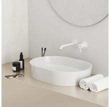 Moderní koupelna s umyvadlem na desku, vodovodní baterií a ručníky