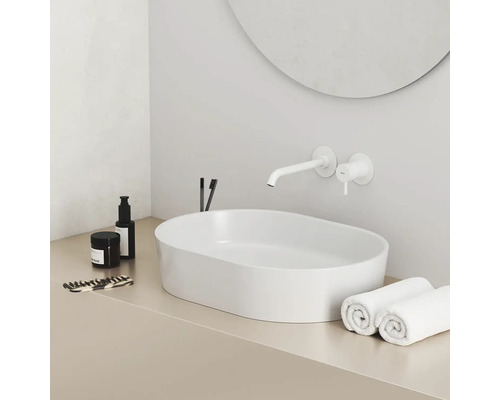 Moderní koupelna s umyvadlem na desku, vodovodní baterií a ručníky