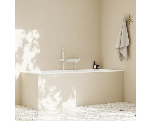 Koupelna s vanou, baterií, ručníkem a kosmetickými produkty