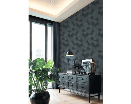 Obývací pokoj s komodou, pokojovou rostlinou a vzorovanou tapetou