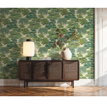 Obývací pokoj s tapetou se vzorem stromů, dřevěnou komodou, stolní lampou a vázou