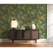 Dekorativní zelená tapeta se vzorem stromů za dřevěnou skříní v místnosti.