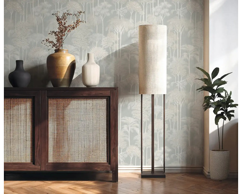 Interiérový pohled s dřevěnou komodou, stolní lampou a pokojovou rostlinou před vzorovanou tapetou