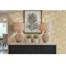 Dekorativní interiér se dvěma lampami, dvěma pokojovými rostlinami, zarámovaným obrazem a komodou před stěnou s palmovým vzorem.