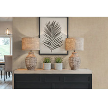 Dekorativní scéna se dvěma stolními lampami, rostlinami a zarámovaným potiskem listů na příborníku