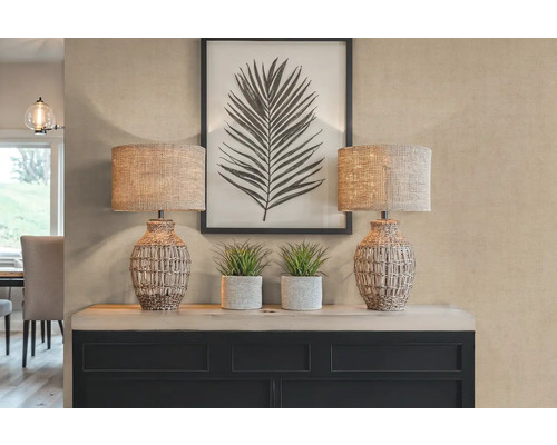 Dekorativní scéna se dvěma stolními lampami, rostlinami a zarámovaným potiskem listů na příborníku