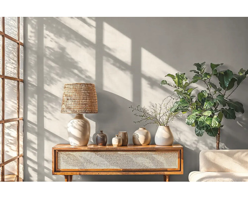 Světlý obývací pokoj s konzolovým stolkem, lampou, vázami a pokojovou rostlinou