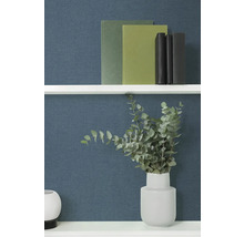 Dekorativní knihy a eukalyptus ve váze na polici.