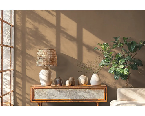 Obývací pokoj s dřevěným stolem, lampou, různými vázami a pokojovou rostlinou